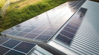 Aerial view of solar panels on the roof of a large storage facility, factory. Providing electricity for the facility, self sufficient facility. Solar panel installation on the roof of a factory. Production of renewable energy concept.